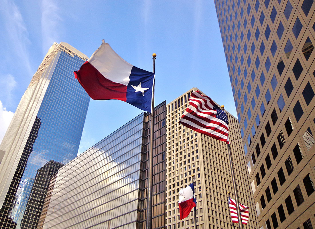 Contact - Looking Up at the Texas Lone Star Flag Next to Modern Skyscrapers Against a Blue Sky in Downtown Houston Texas