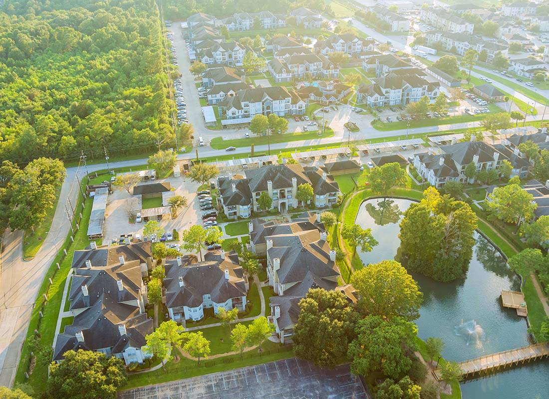 Pasadena, TX - Aerial View of a Quiet Suburban Neighborhood with Multi Story Homes Surrounded by Green Grass and Trees in Pasadena Texas in the Early Morning